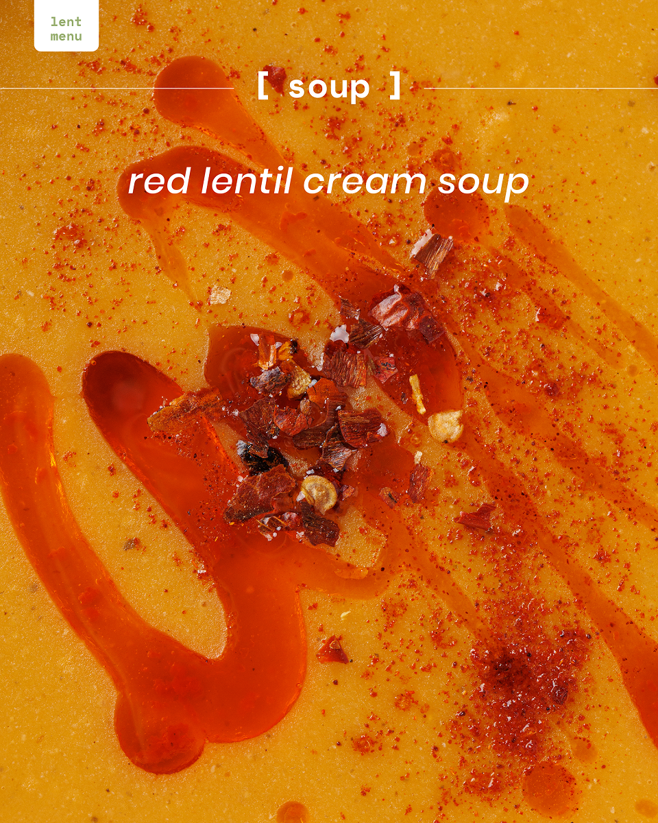 Close-up of creamy red lentil soup with chili flakes and oil drizzle on top.